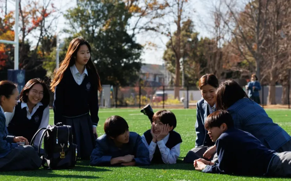 Rugby School 校園草地上穿著制服的學生們開心談笑